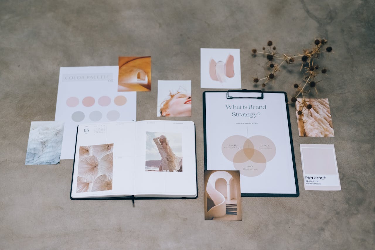 A flat lay of branding elements with color palettes and strategic planning documents on a concrete surface.